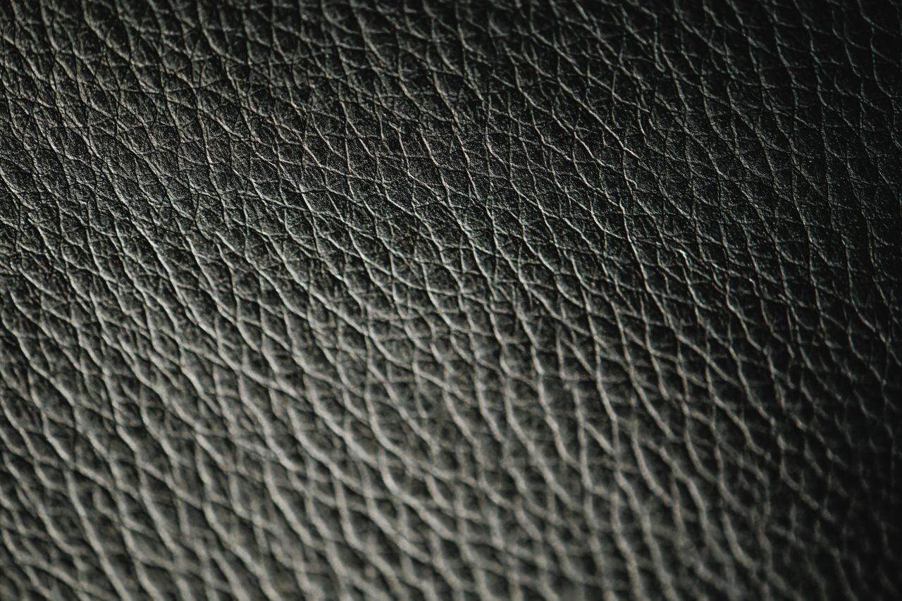 Macro photograph showcasing the intricate texture and pattern of black leather.
